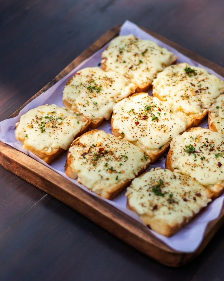 Tostadas de pan con queso gratinado sobre una tabla de madera