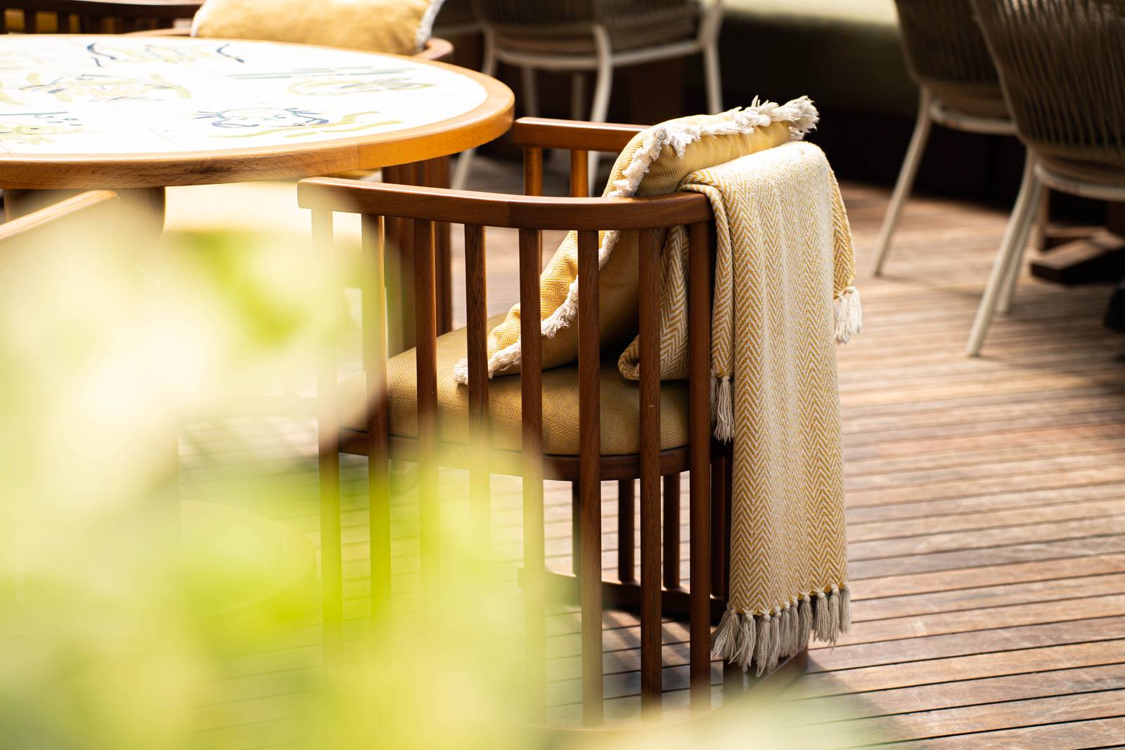 Mesa de la terraza con sillas de mimbre y una manta